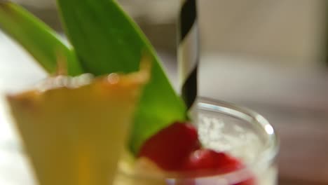 Close-up-focus-rack-of-pina-colada-cocktail-on-table,-with-raspberries-and-pineapple