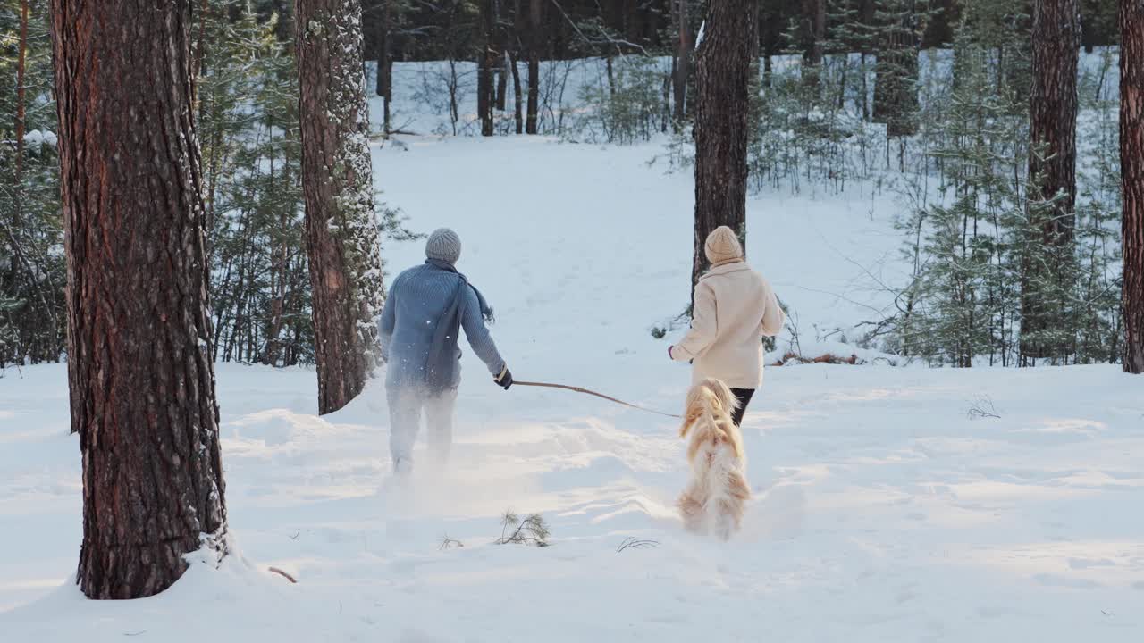 Couple and Dog Enjoying a Winter Walk in the Forest