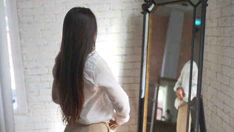 woman trying on clothes in front of mirror