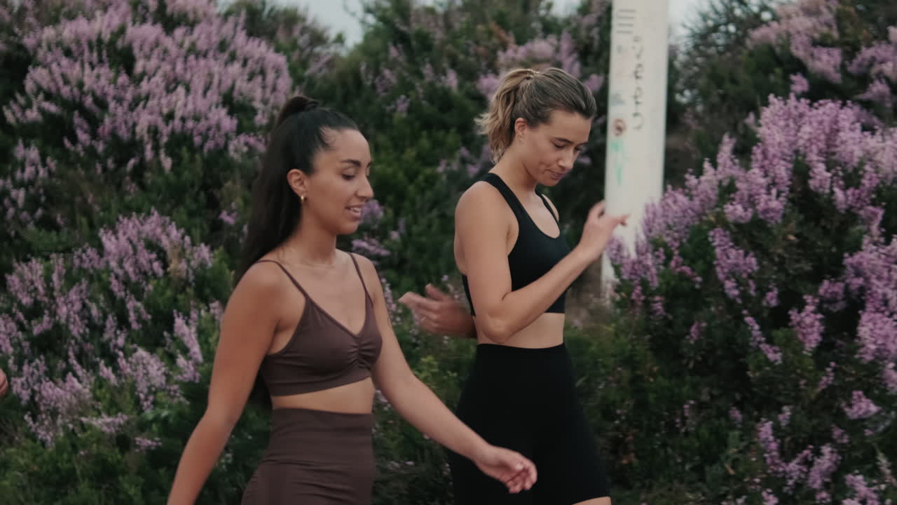 Two Fitness Women Walk and Talk Outdoors