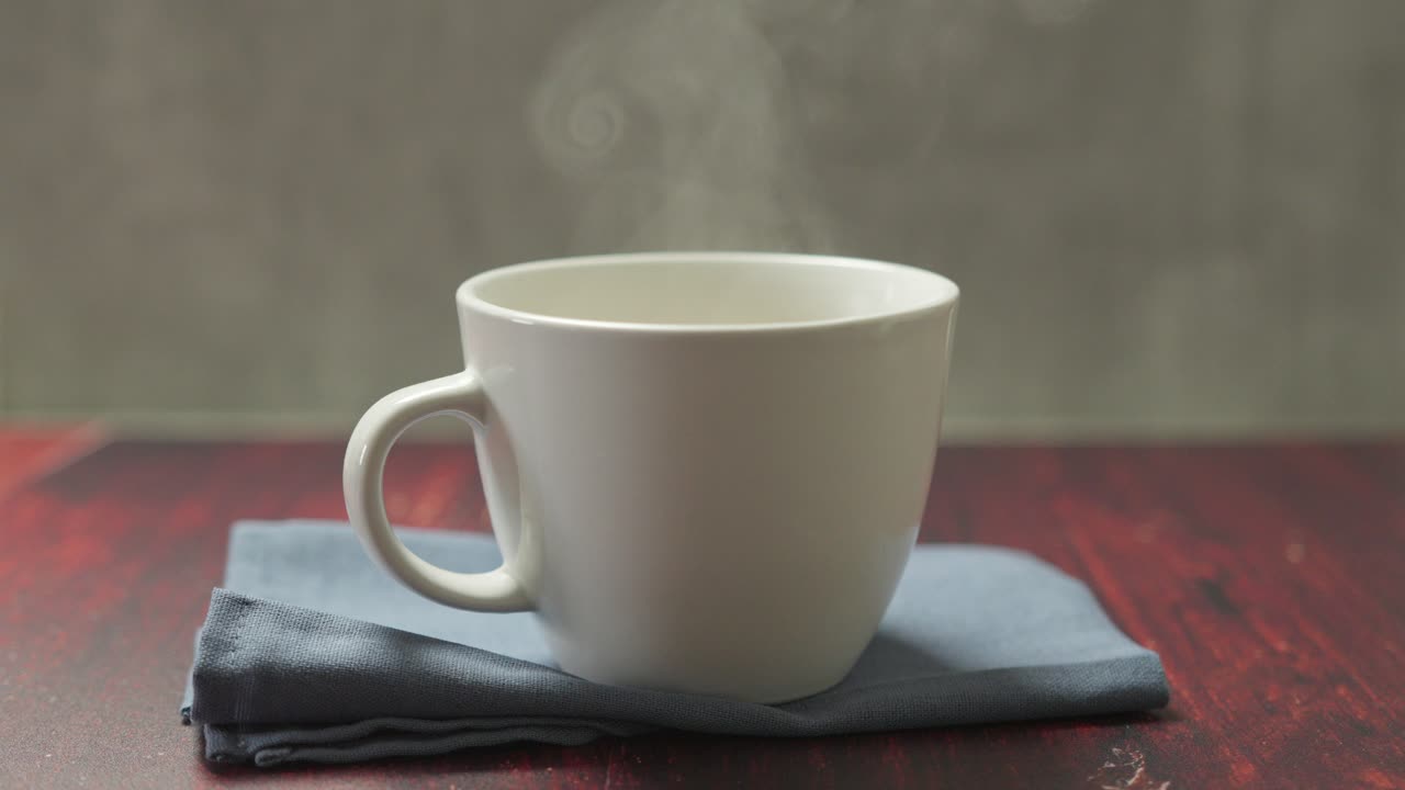 A freshly made vanilla latte sits in a white mug on the table, its creamy surface gently swirling with warmth.