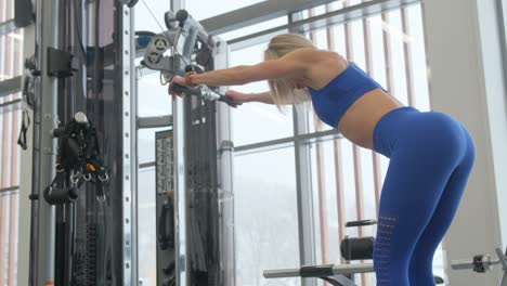 woman working out on a cable machine in a gym