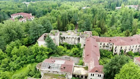 massive derelict sanatorium building in georgia, aerial fly toward view