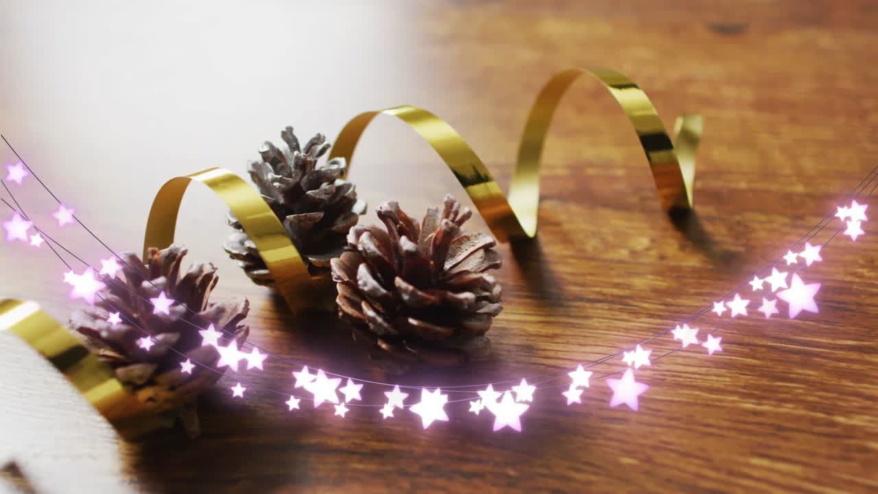 Pine cones and golden ribbon with glowing star animation on wooden surface