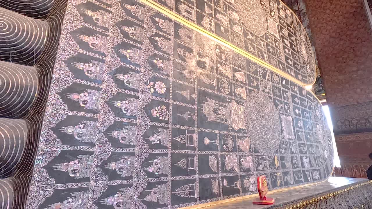 포 (wat pho) 의 누워있는 부처님의 발에 있는 복잡한 패턴의 상세한 시각, 따뜻한 조명으로 찍혔다.