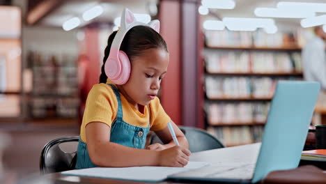 chica estudiando en una biblioteca con auriculares y portátil