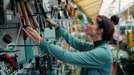 pretty young brunette woman choosing some garden equipment for her garden