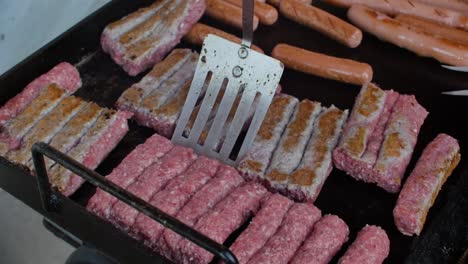 volteando la carne picada a la parrilla con una cuchara de aluminio