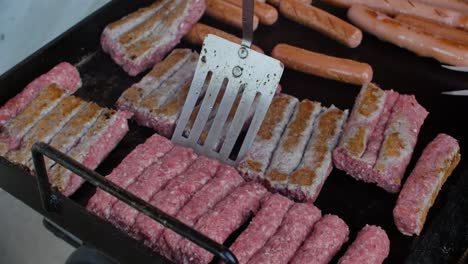 flipping over minced meat on grill with aluminium spoon