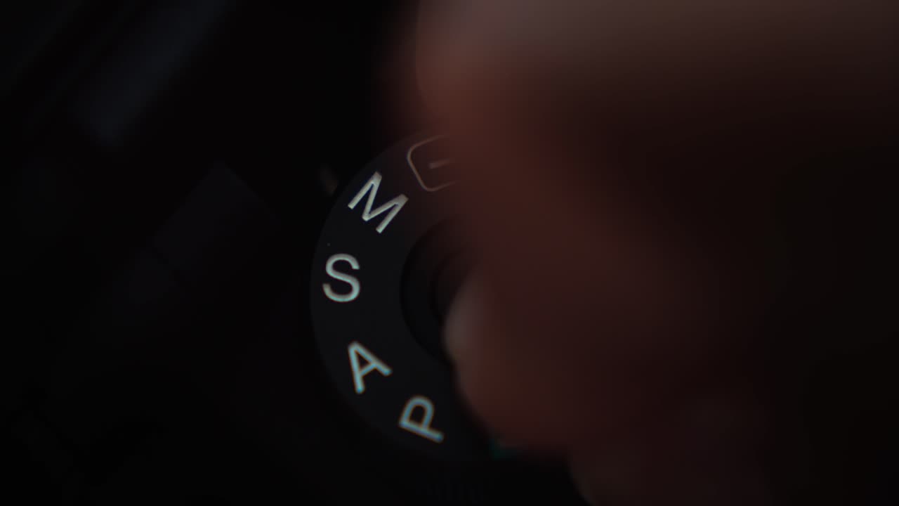 수동 노출 모드에서 카메라를 퍼팅하는 손가락의 정적 샷을 닫습니다.