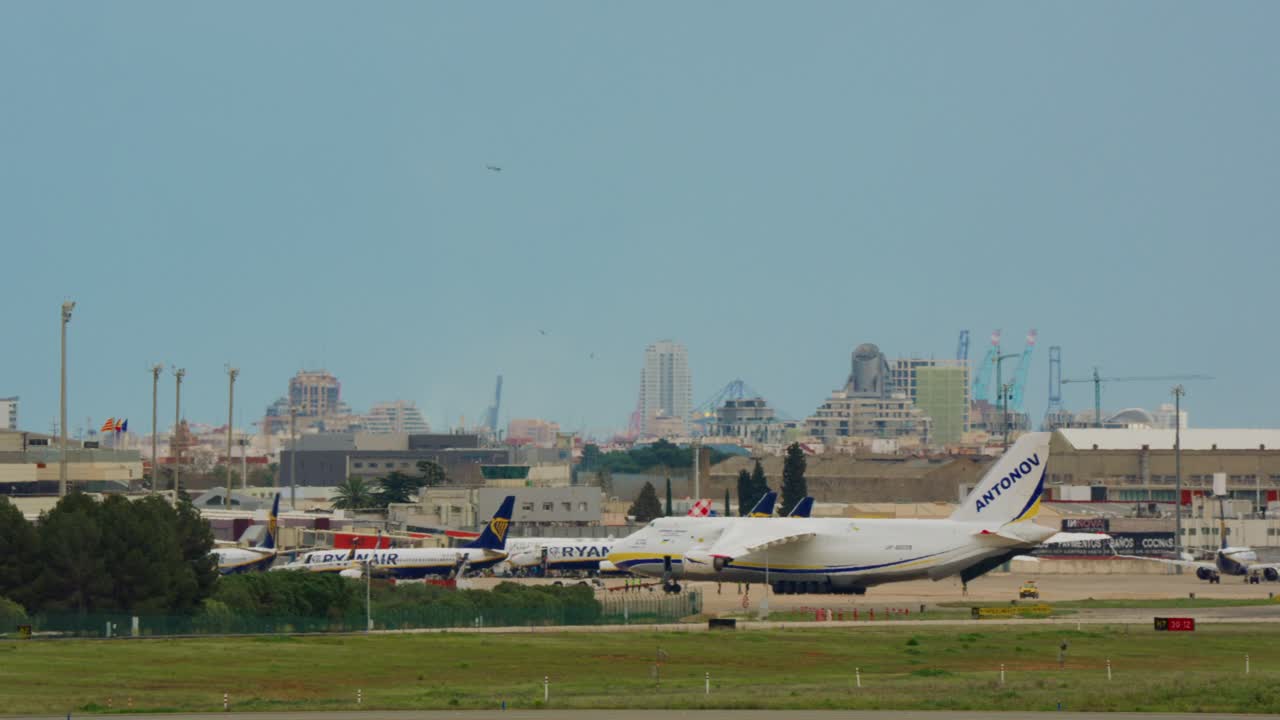 都市のスカイラインを背景に空港に駐機しているアントノフAn-124輸送機