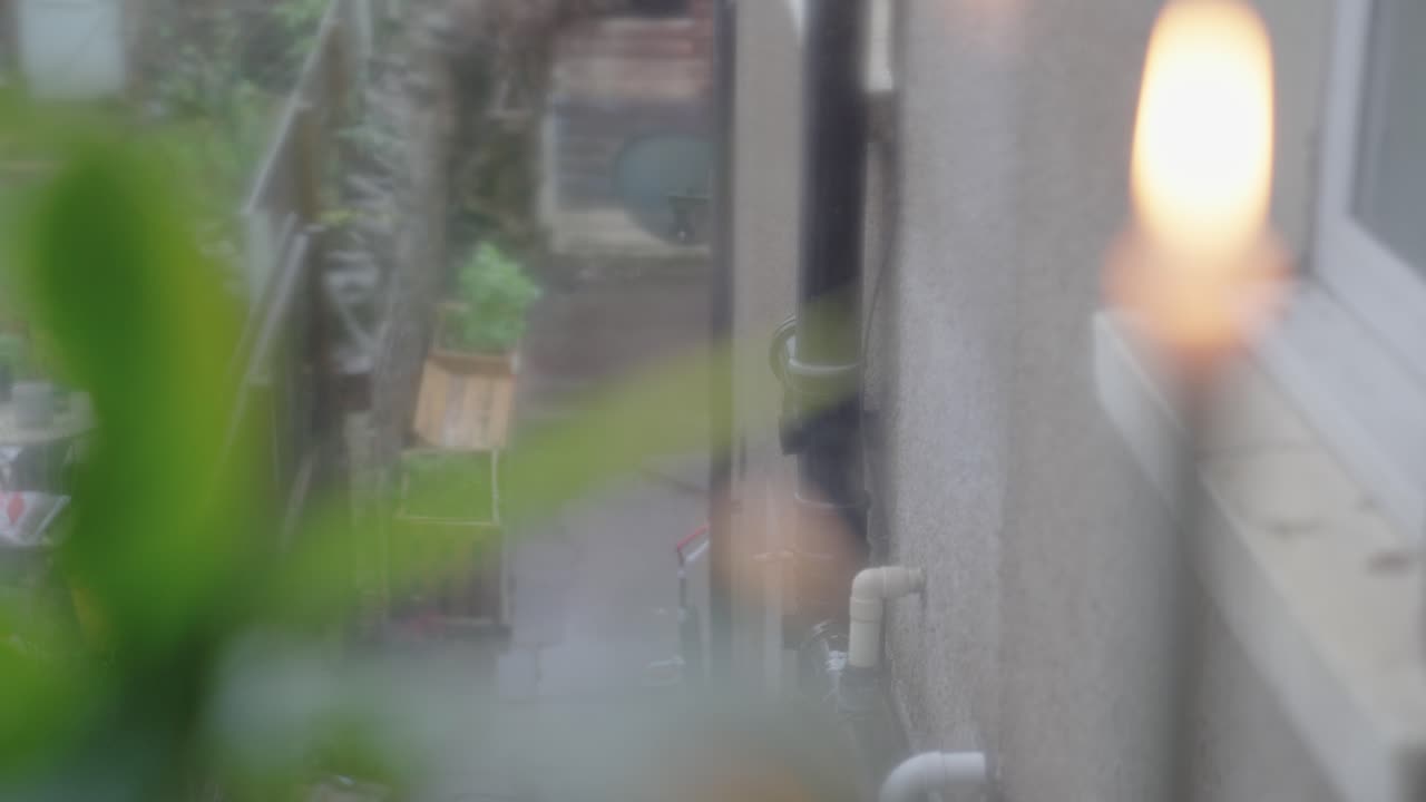 비오는 날 창가에 있는 촛불과 평화 백합