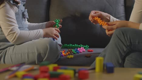 close up of girl on asd spectrum being helped or assessed by female teacher or educational psychologist at home 1