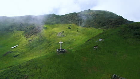 Drone-shot-Nepal's-cross-Jesus-Christ-structure-in-Green-Hills,-Himalayan-region,-greenery-religious-Christianity-faith