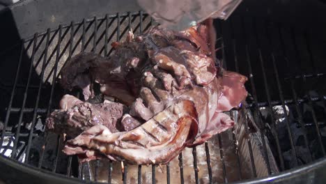 pouring marinade over venison wrapped in bacon on a open fire