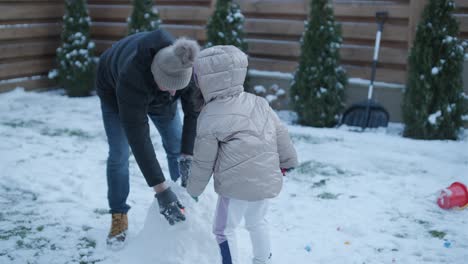 grandfather and granddaughter having fun in the snow