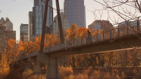 side view of caucasian man standing on bridge with bicycle in the city 4k