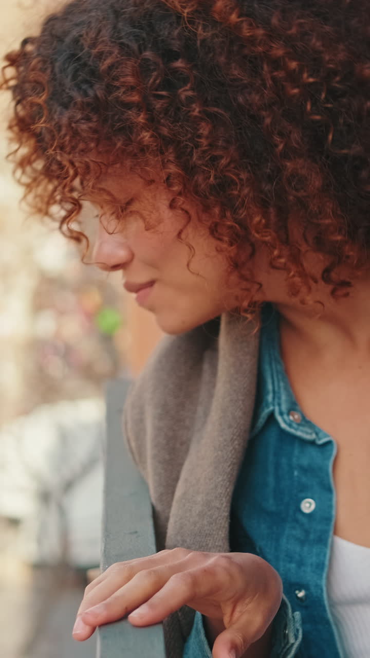Portrait of a Smiling Young Woman with Curly Hair Outdoors