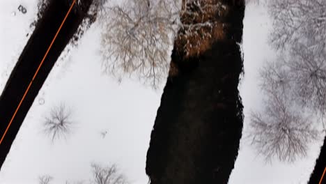 Una-Vista-Aérea-De-Un-Parque-Cubierto-De-Nieve-En-Un-Día-Nublado-De-Invierno