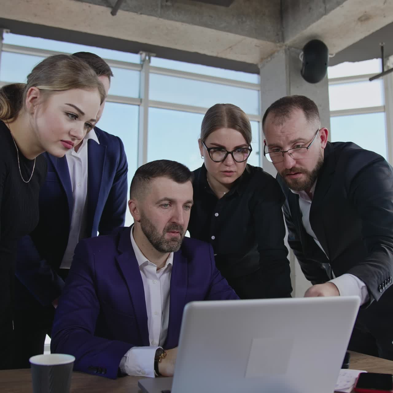 Office team stand near boss and his laptop and offer ideas. Brainstorming and ideas sharing for better results in work. Panoramic windows with cityscape at the backdrop
