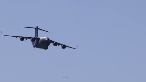 a large military aircraft flying against a clear sky