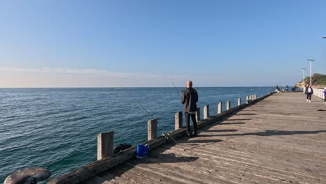 man fishing on a sunny pier