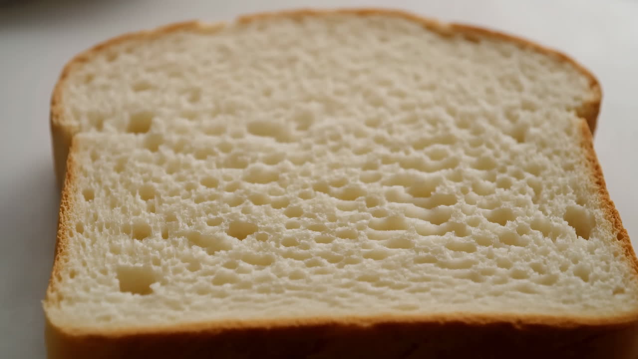Soft White Bread Slice Close Up, Studiolit Minimalist Scene Showing Airy Porous Crumb And Thin Golden Crust