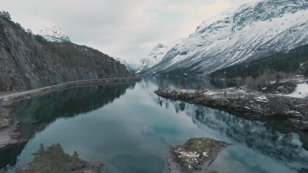 majestuoso paisaje montañoso de noruega con picos nevados y aguas cristalinas del lago, lovatnet