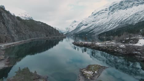 majestic norway mountain landscape with snow covered peaks and crystal clear lake water, lovatnet