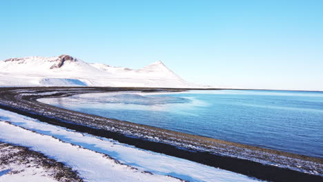 Snaefellness-Peninsula-in-winter-season-covered-in-white-snow-during-a-sunny-day-aerial-footage-of-Iceland