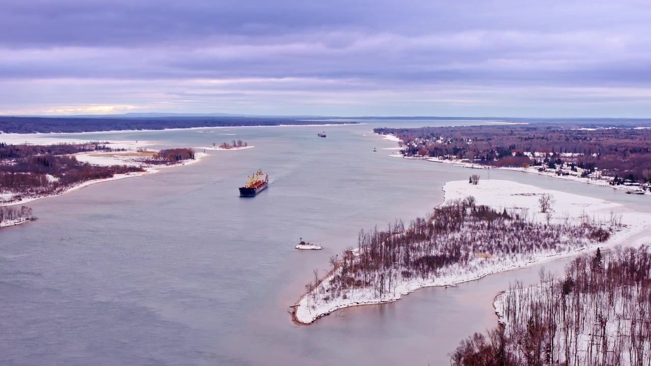 Kuzey Michigan'daki Soo Kilitleri'ne giden bir yük gemisiyle St. Mary Nehri üzerinde süzülen drone görüntüleri.