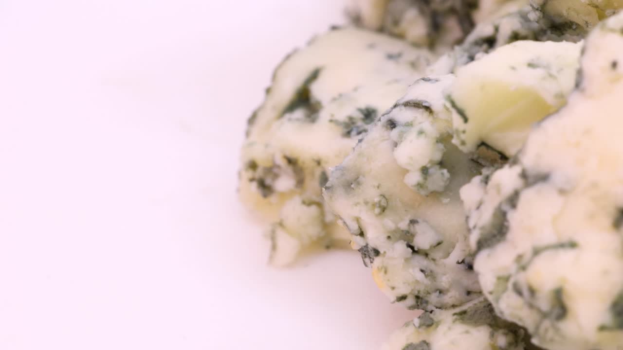 trozos de queso azul picados en una vista de primer plano extrema, toma macro en 4k en el lado derecho del marco