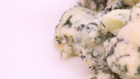 trozos de queso azul picados en una vista de primer plano extrema, toma macro en 4k en el lado derecho del marco