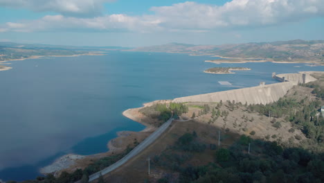 represa hidroeléctrica con paneles solares flotantes y turbinas eólicas en el fondo vuelan por