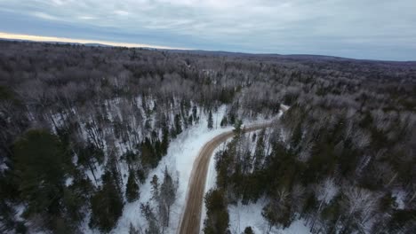 aerial view of a snowy forest road in winter