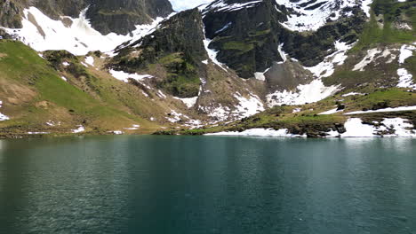 aerial: lake lioson during the day with snow in ormont-dessous, near les mosses, in the canton of vaud, switzerland, push in drone shot