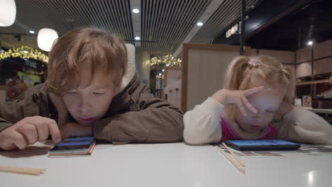 kids using phones while waiting for food in cafe