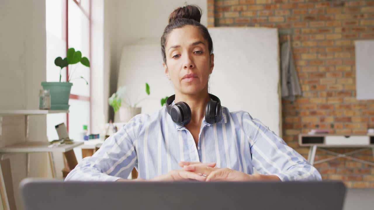 video de una feliz diseñadora biracial haciendo una videollamada en el estudio
