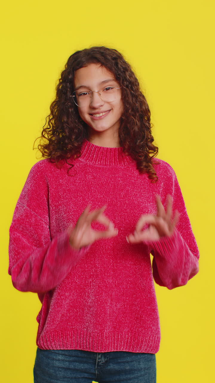 Smiling happy girl makes heart gesture demonstrates love sign expresses good feelings and sympathy