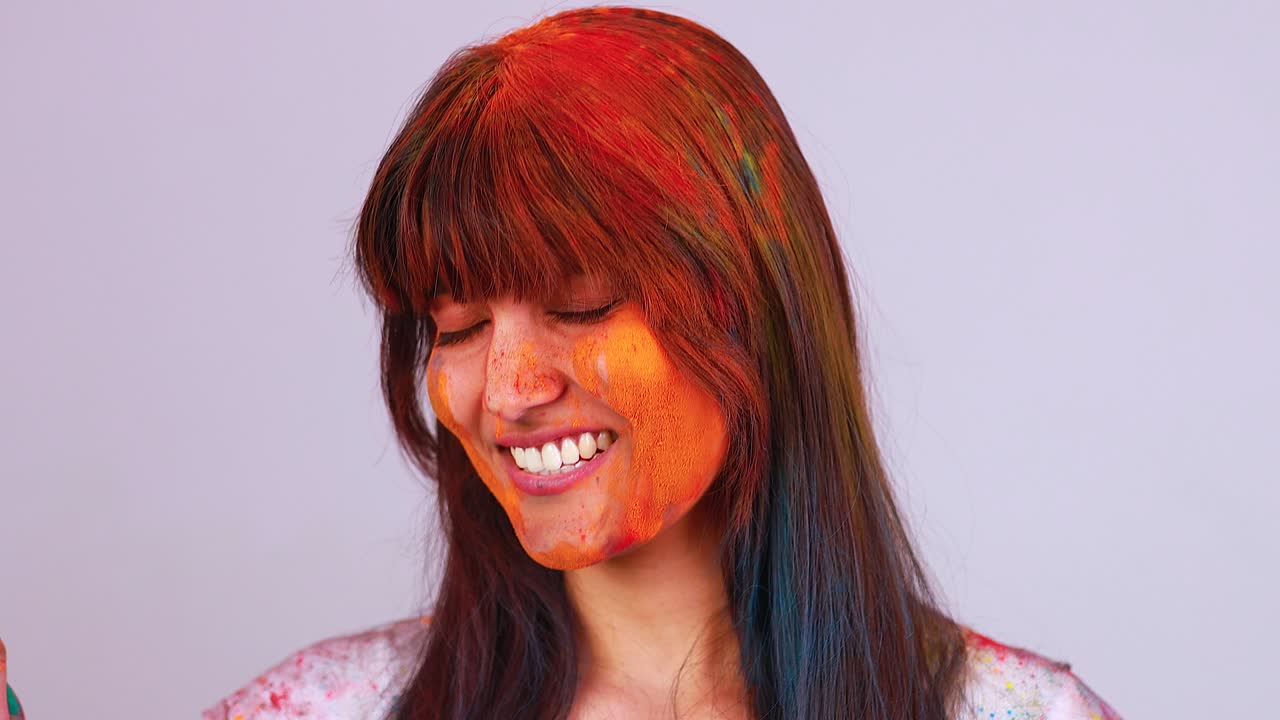 아름다운 인도 학생 여성은 스튜디오에서 홀리 축제를 축하하는 색으로 칠해져 있습니다. 색 고립 된 배경