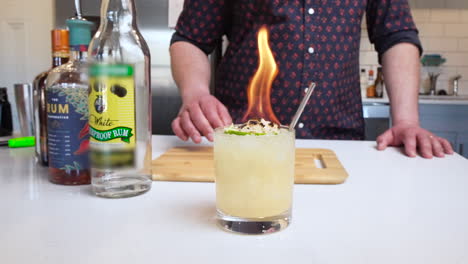 bartender puts flaming cocktail down on bar in slow motion