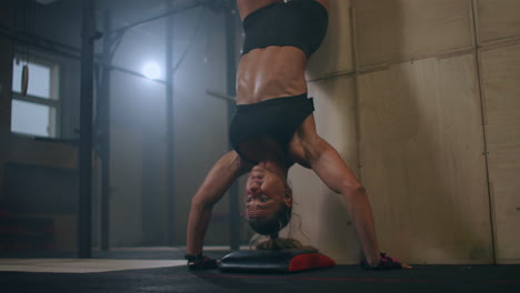 Una-Mujer-Fuerte-Realiza-Flexiones-Verticales-De-Pie-Sobre-Su-Cabeza-En-El-Gimnasio.-Realiza-Flexiones-Al-Revés.-Flexiones-Contra-La-Pared-Al-Revés