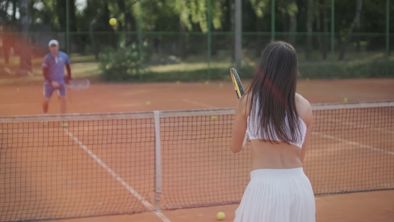 여자 테니스 선수 가 야외 코트 에서 세브 를 연습 하고 있다