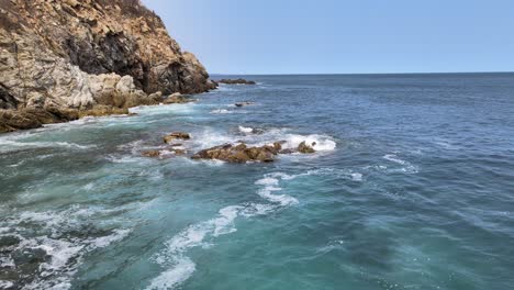 tirar al frente junto al acantilado con vista al océano, las olas y las rocas en un día soleado