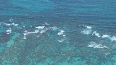 aerial shot of ocean waves flowing over the coral reef