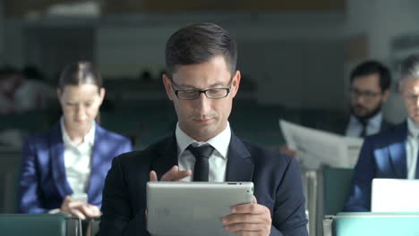 Hombre-De-Negocios-Usando-Su-Tableta-En-El-Vestíbulo-Del-Aeropuerto-Esperando-Su-Vuelo