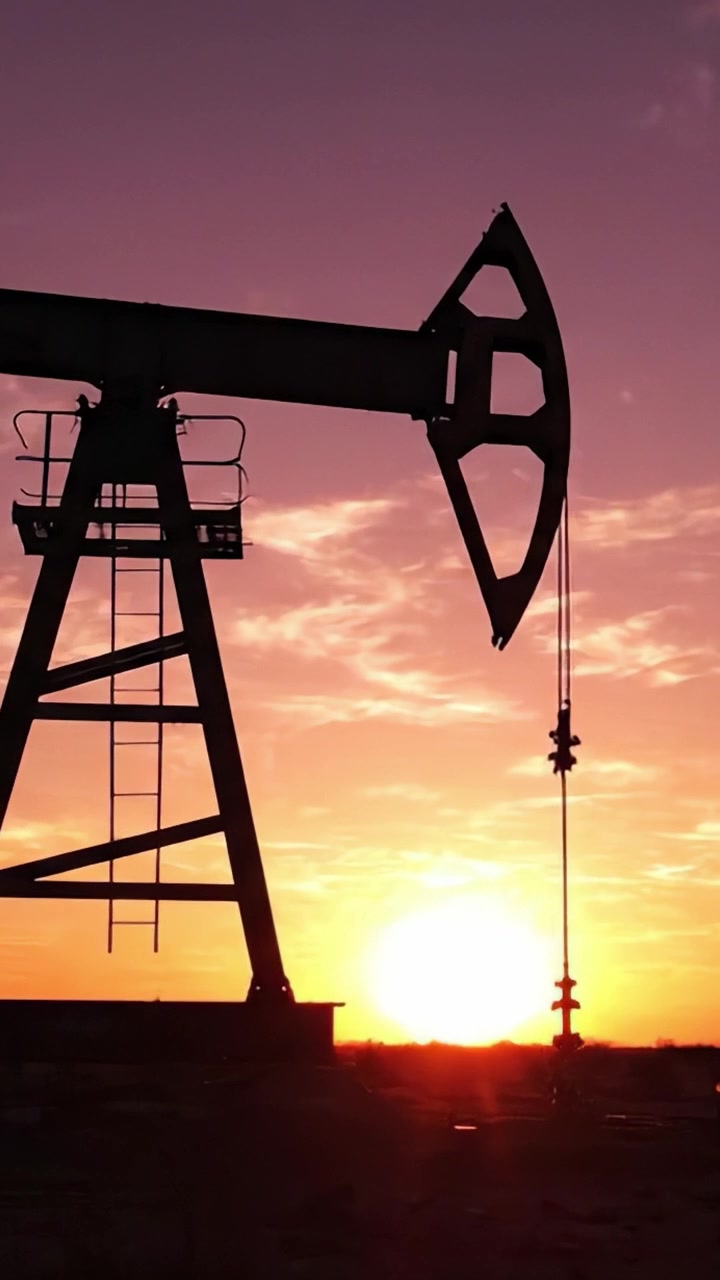 Stunning Silhouette of an Oil Pump Jack Against a Vibrant Sunset Sky, Capturing the Essence of Energy Production and Natural Beauty in Harmony.