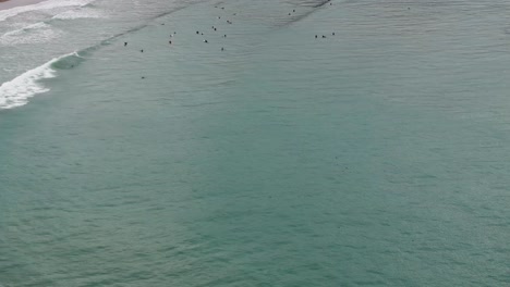 Drone-aerial-view-of-hundreds-of-surfers-surfing-in-pacifica,-california