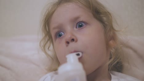 little-blonde-girl-undergoes-procedure-with-inhaler-in-bed