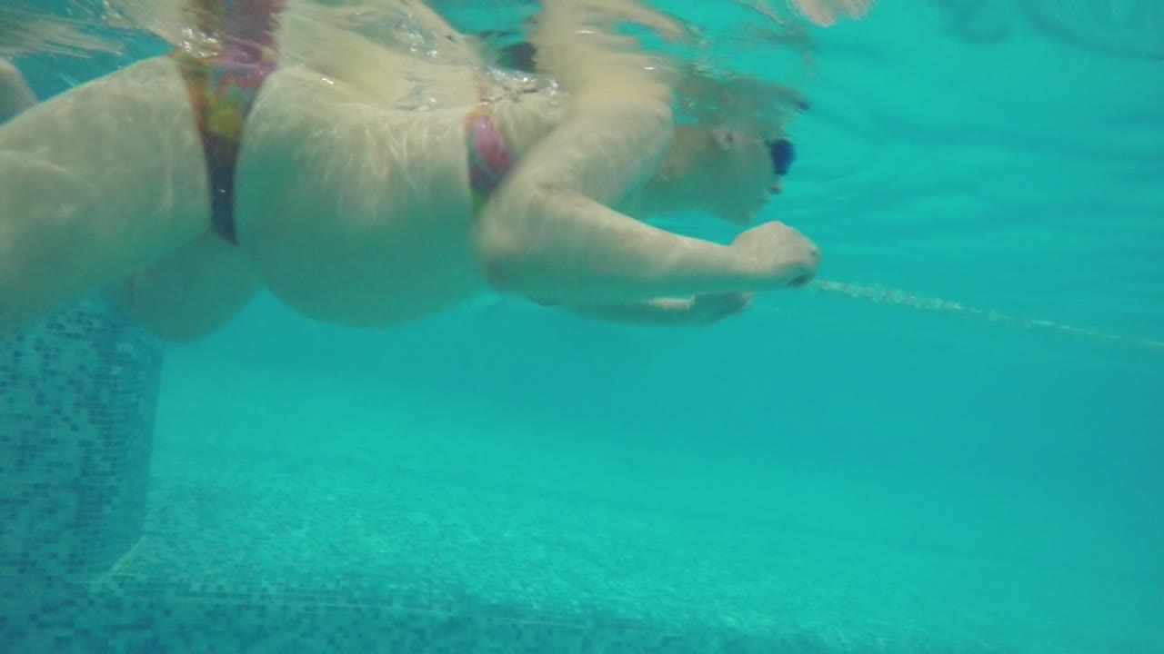 수영장 에서 수영 하는 임신 한 여자 의 수중 풍경